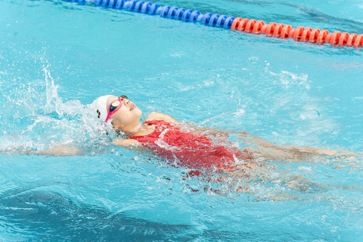 girl in complete swimming gear floating on her back